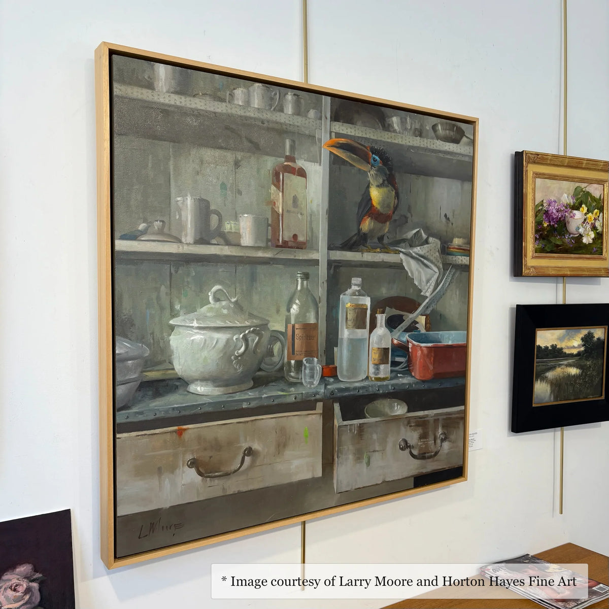 Surrealist figurative art by Larry Moore at Horton Hayes Fine Art, framed in a natural maple floater frame. Interior scene.