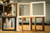 Modern picture frames stacked upright in walnut, natural maple, white, black and burl wood finishes